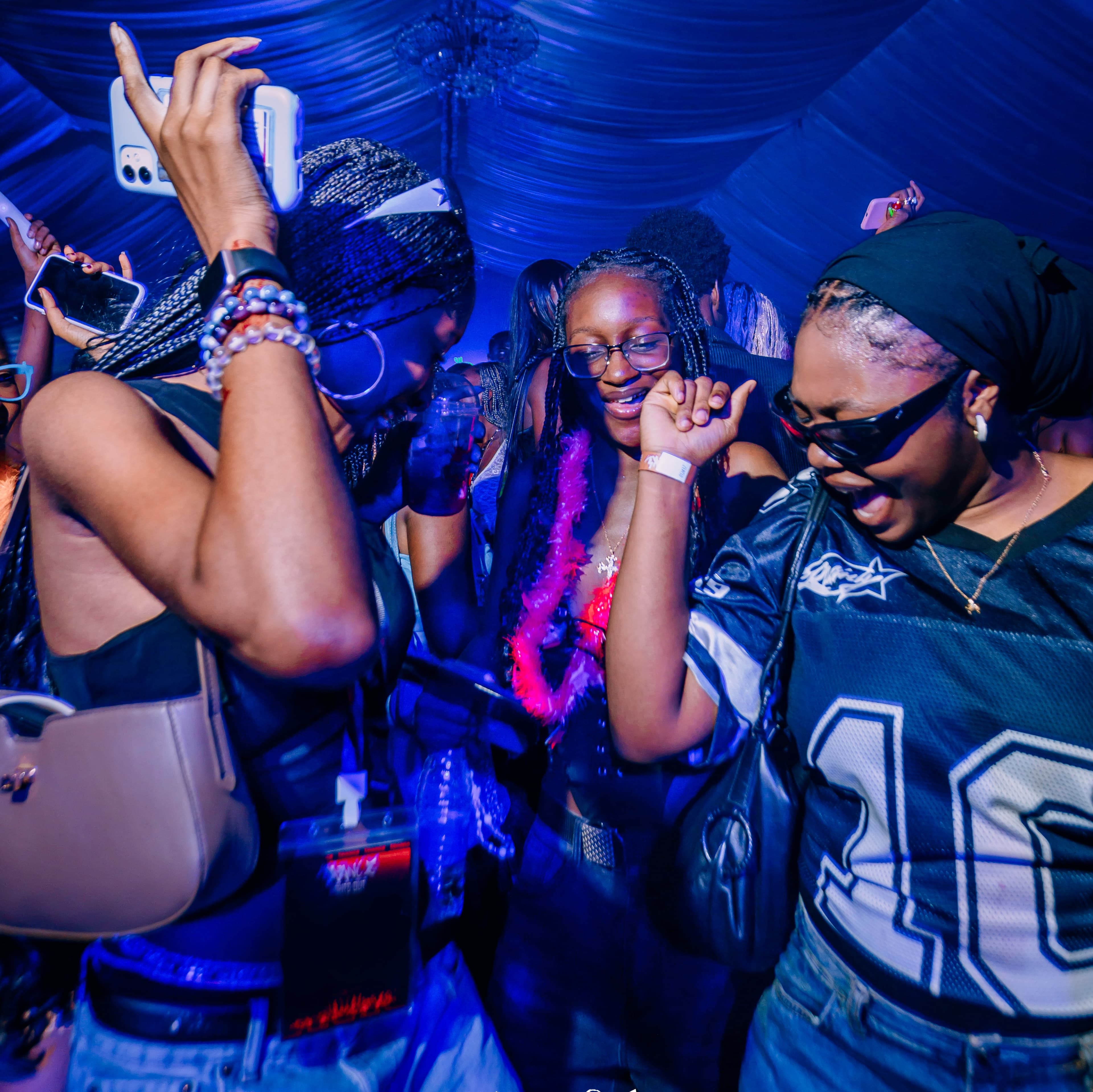 Friends dancing together under vivid blue lights at Trance